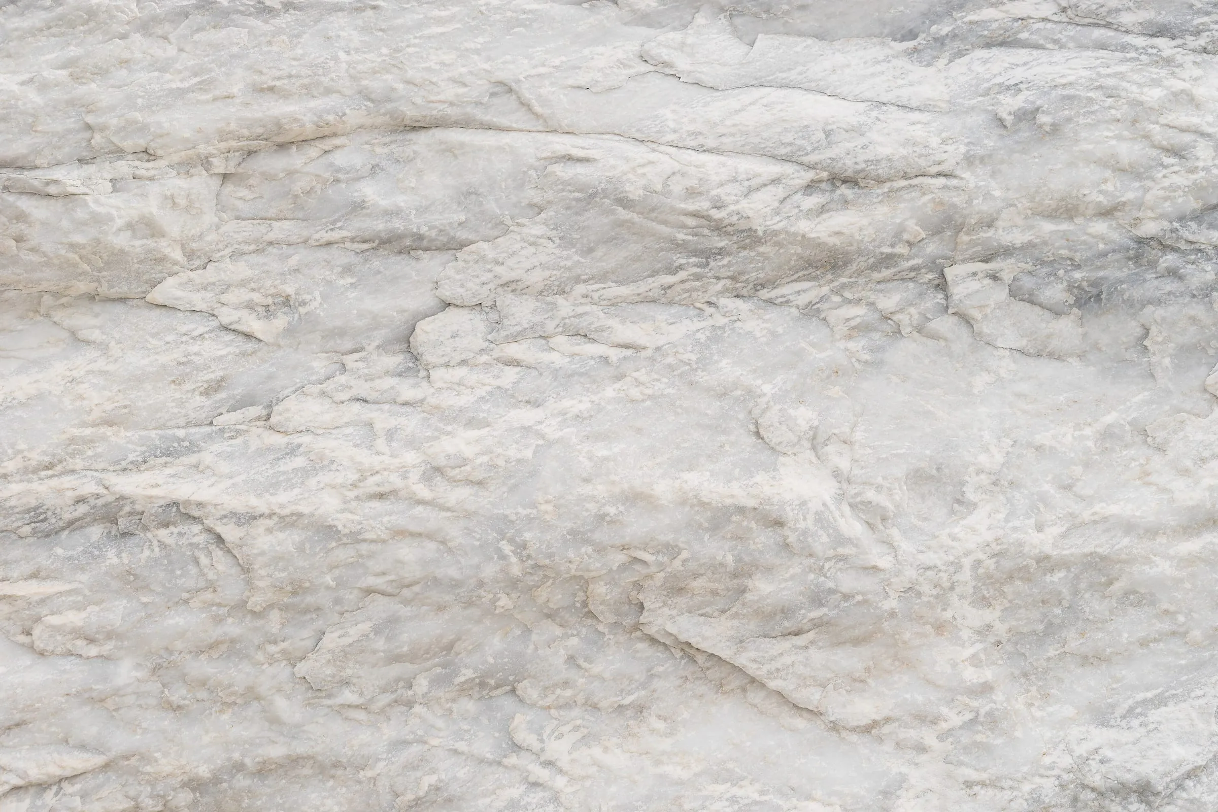 Close material-reference photograph of white Kymi marble from Euboea, showing natural surface variation at hand-sample scale.