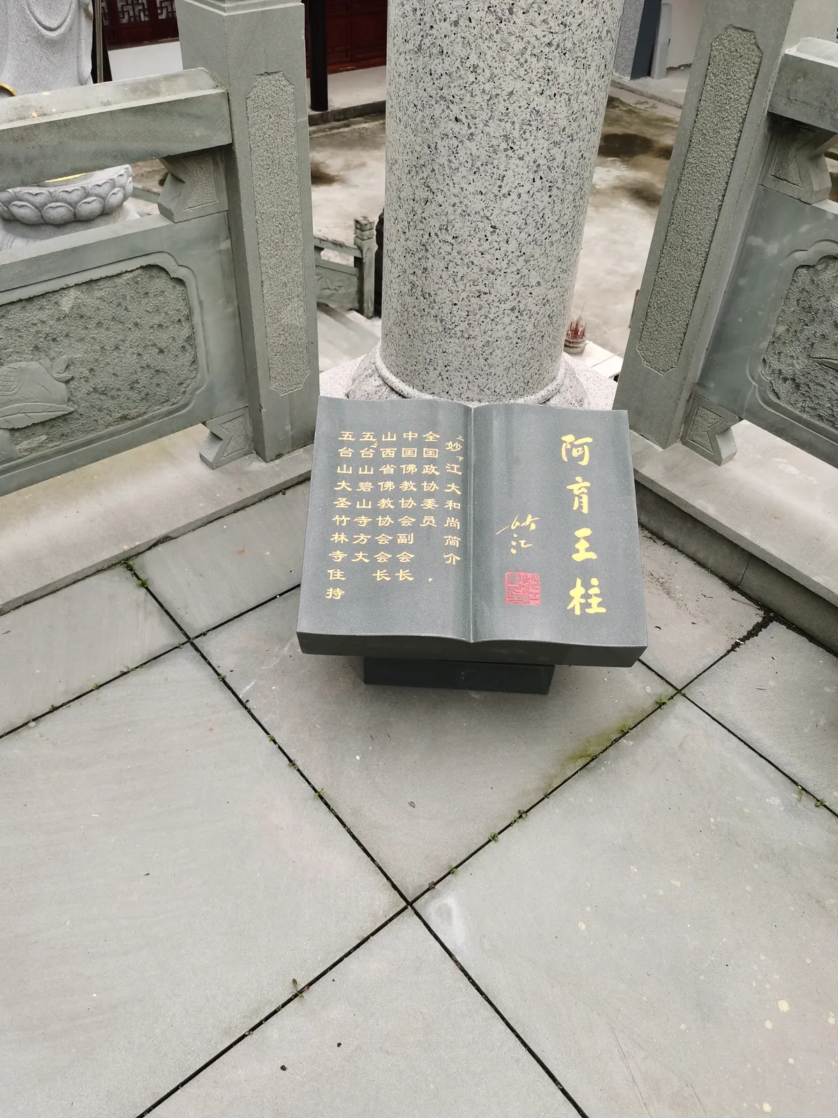 Carved column base with incised calligraphy and relief ornament.