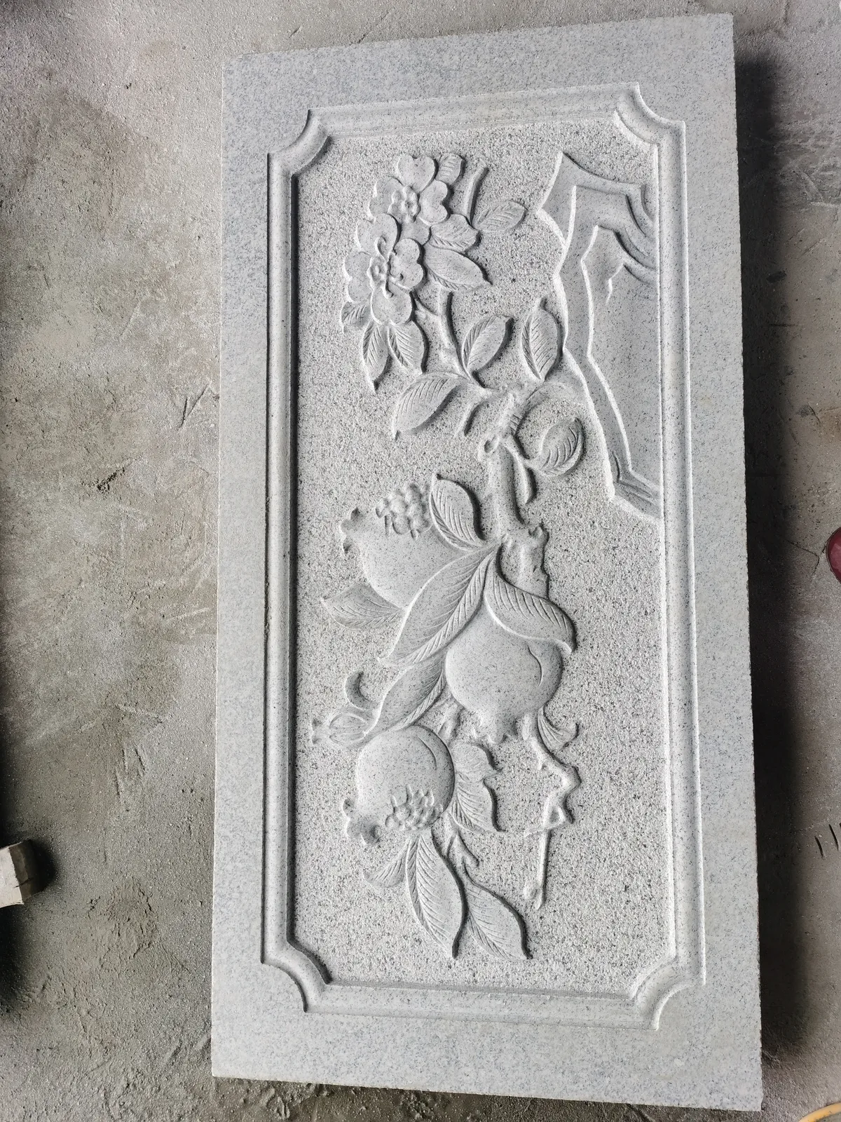 High-relief stone carving of flowers and fruit with deep undercutting.