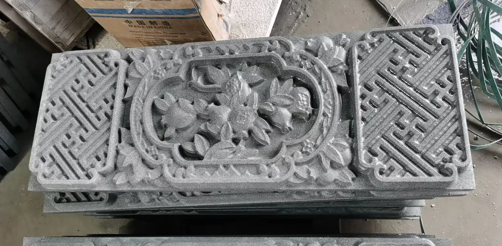 Stone panel carved fully through in a pierced openwork lotus pattern.